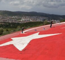 Yozgat'ta bir vatandaş, tepenin yamacındaki rengi solan dev Türk bayrağını boyuyor