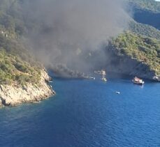 Fethiye'de bir koyda teknede çıkan yangına müdahale ediliyor